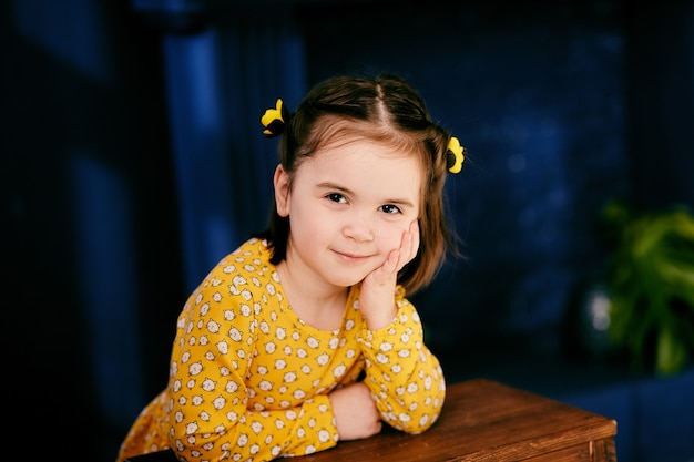 Foto gratuita la pequeña niña se encuentra cerca de la mesa