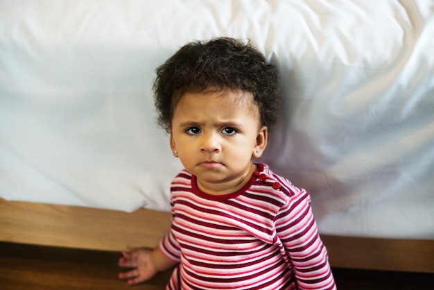 Pequeña niña pequeña con una mirada seria en su cara