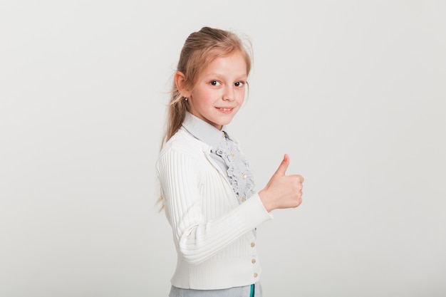 Foto gratuita pequeña niña con pulgar levantado