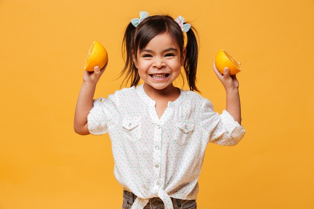 Pequeña niña que sostiene la naranja.