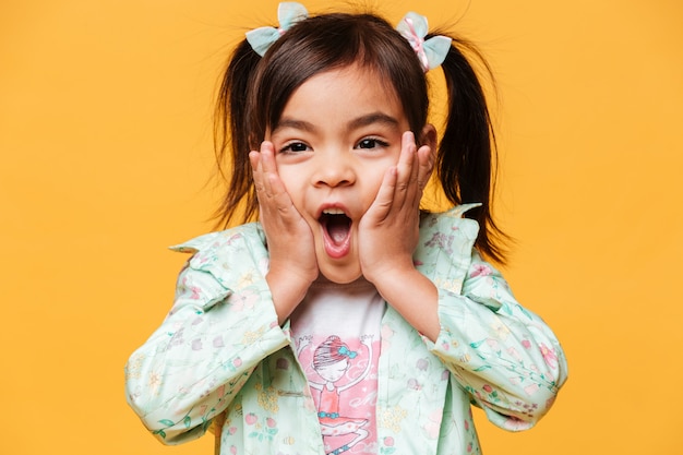 Pequeña niña sorprendida que se coloca aislada