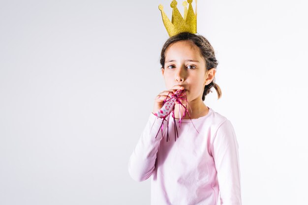 Pequeña princesa soplando cuerno partido