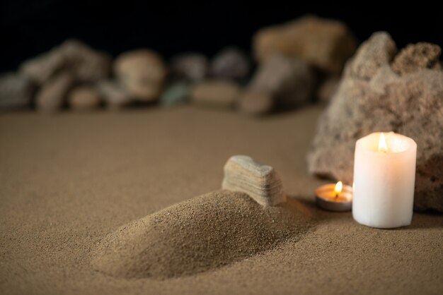 Pequeña tumba con velas y piedras sobre la arena la muerte de la guerra fúnebre