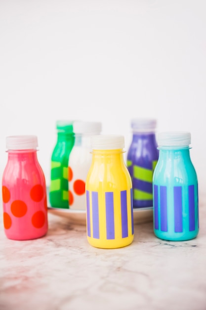 Pequeñas botellas de leche coloridas en la placa