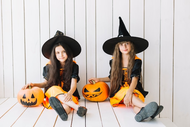 Pequeñas brujas con calabazas en el evento de Halloween
