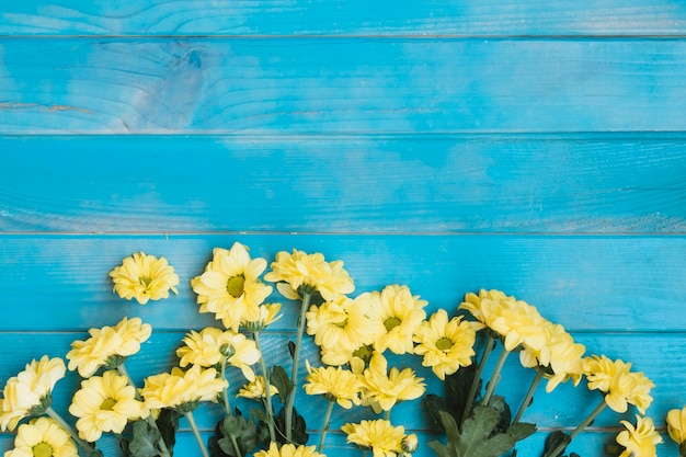 Foto gratuita pequeñas flores amarillas en la mesa de madera