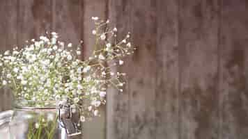 Foto gratuita pequeñas flores blancas sobre fondo de madera
