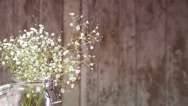 Pequeñas flores blancas sobre fondo de madera