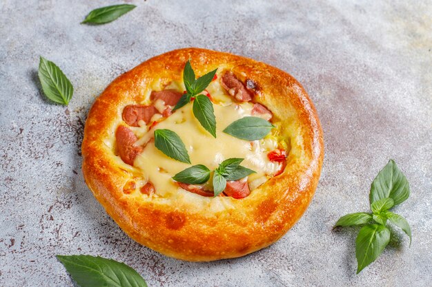 Pequeñas pizzas caseras frescas con albahaca.