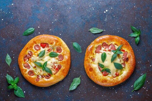 Pequeñas pizzas caseras frescas con albahaca.