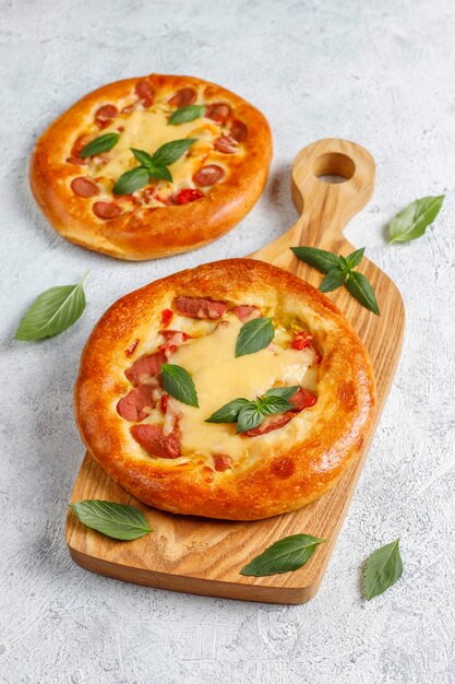 Pequeñas pizzas caseras frescas con albahaca.