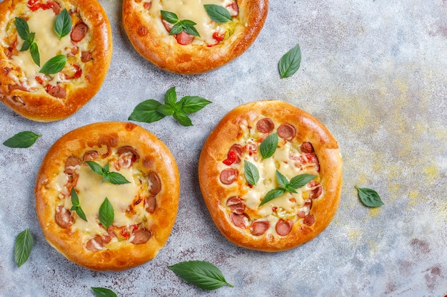 Pequeñas pizzas caseras frescas con albahaca.