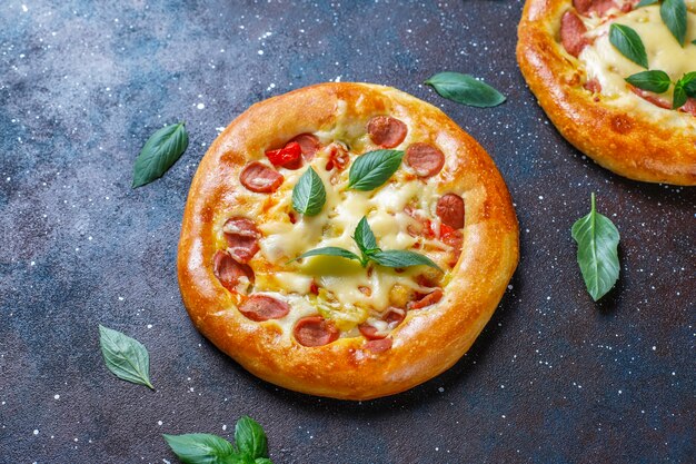 Pequeñas pizzas caseras frescas con albahaca.