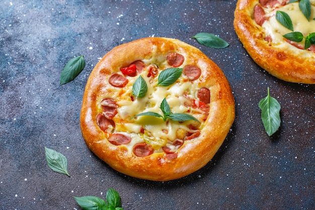 Pequeñas pizzas caseras frescas con albahaca.