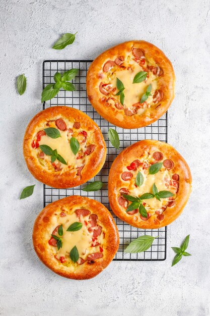 Pequeñas pizzas caseras frescas con albahaca.