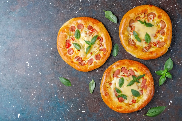 Pequeñas pizzas caseras frescas con albahaca.