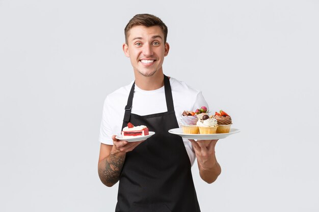 Pequeñas tiendas de café de negocios minoristas y concepto de panadería amable camarero barista guapo en negro apro ...