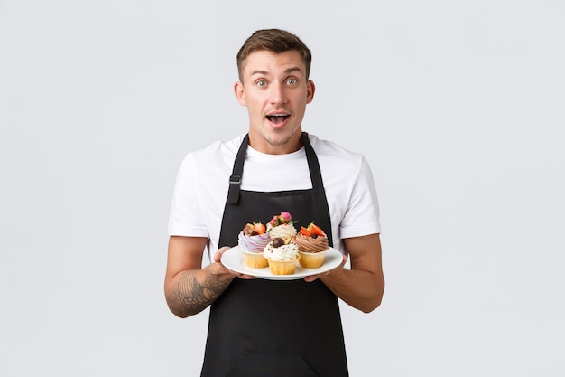 Pequeñas tiendas de café de negocios minoristas y concepto de panadería emocionado vendedor barista guapo en abril negro ...