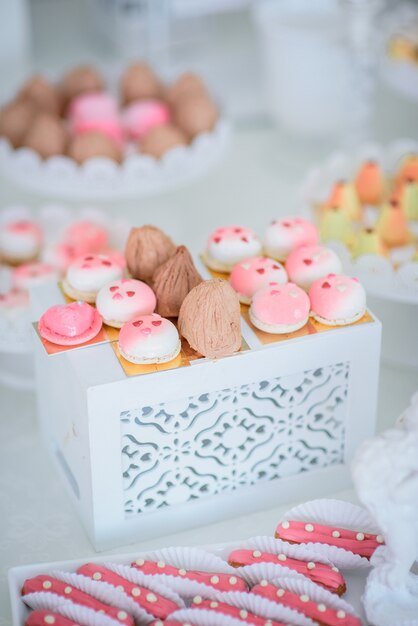 Pequeñas tortas y canutillos rosados ​​y blancos