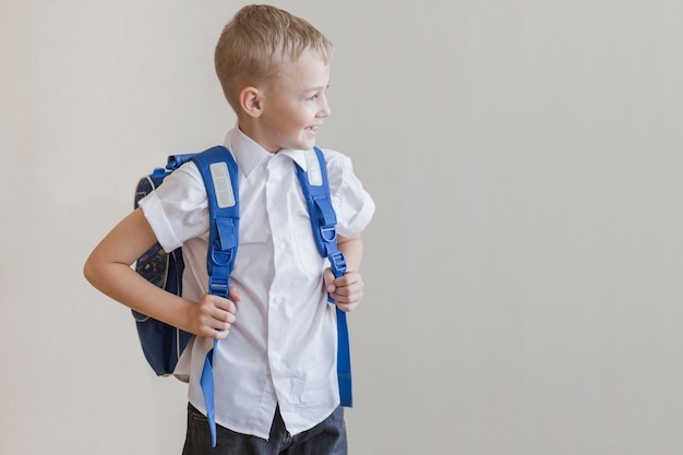 Pequeño alumno con mochila en estudio