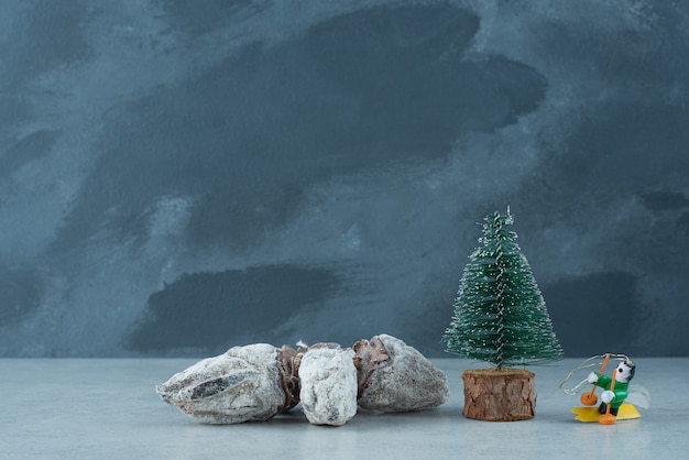 Foto gratuita pequeño árbol de navidad con frutos secos saludables sobre fondo de mármol. foto de alta calidad