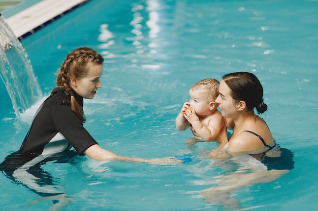 Pequeño bebé lindo. Instructor con niño. Madre con hijo