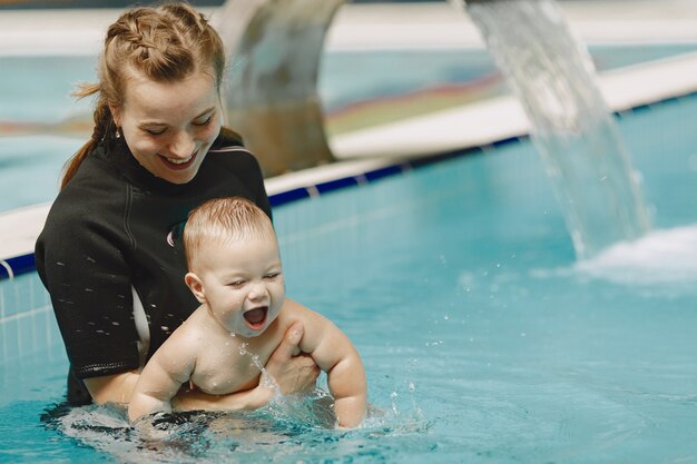 Pequeño bebé lindo. Instructor con niño. Madre con hijo