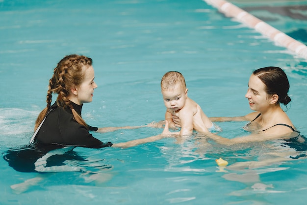 Pequeño bebé lindo. Instructor con niño. Madre con hijo