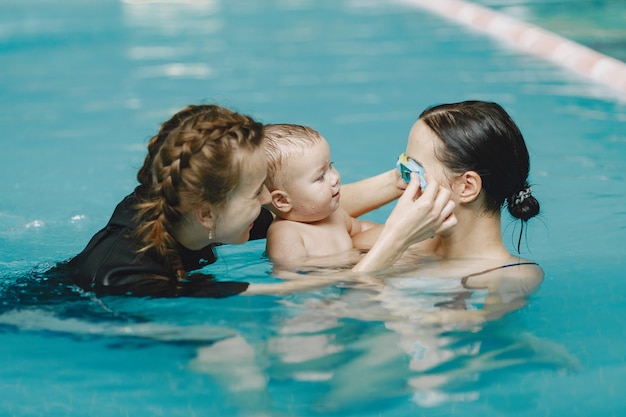 Pequeño bebé lindo. Instructor con niño. Madre con hijo