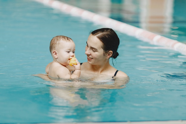 Pequeño bebé lindo. Madre con hijo. Familia jugando en un agua