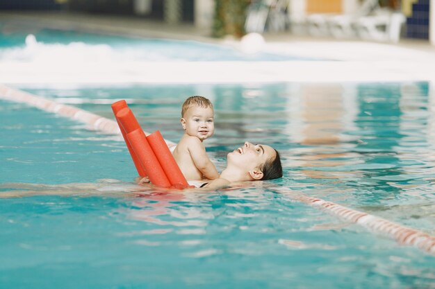 Pequeño bebé lindo. Madre con hijo. Familia jugando en un agua