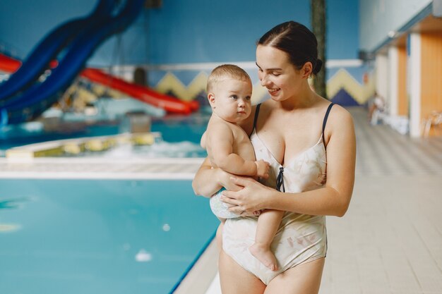 Pequeño bebé lindo. Madre con hijo. Familia jugando junto al agua