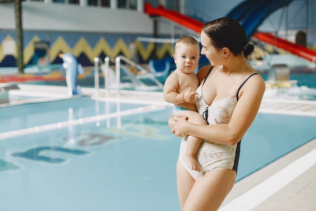 Pequeño bebé lindo. Madre con hijo. Familia jugando junto al agua