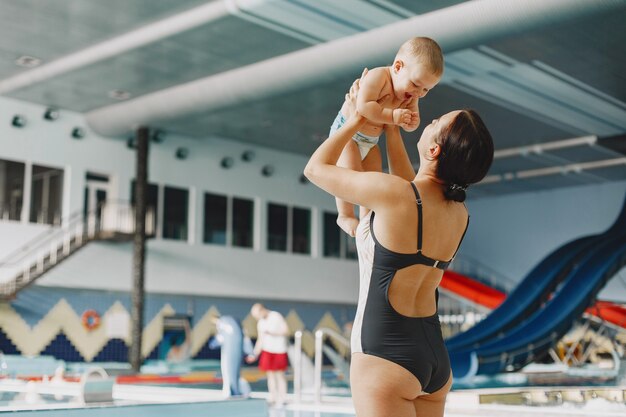 Pequeño bebé lindo. Madre con hijo. Familia jugando junto al agua