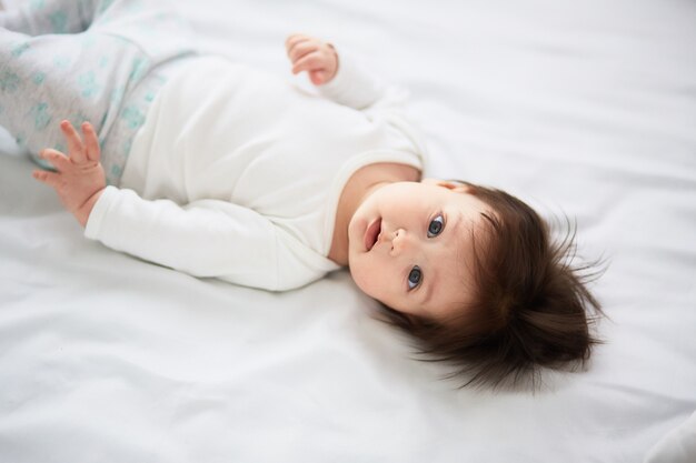 El pequeño bebé yace en la cama