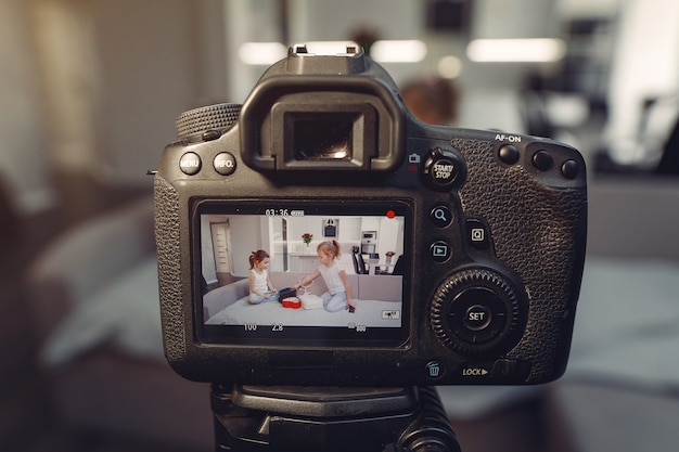 Pequeño blogger lindo con cosméticos grabando video en casa