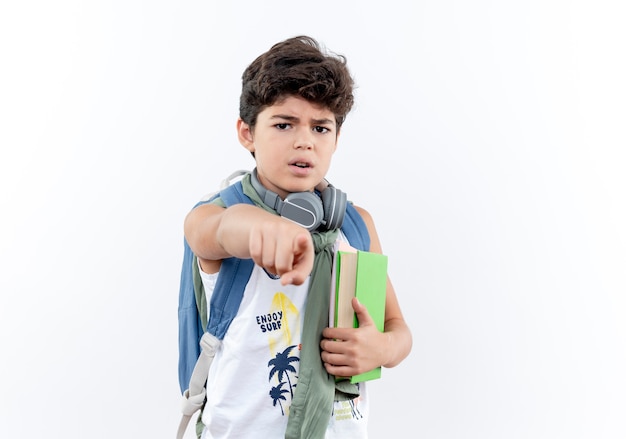 pequeño colegial con mochila y auriculares sosteniendo libros y puntos en la parte delantera