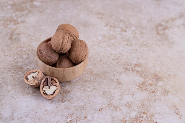 Un pequeño cuenco de madera lleno de nueces saludables.