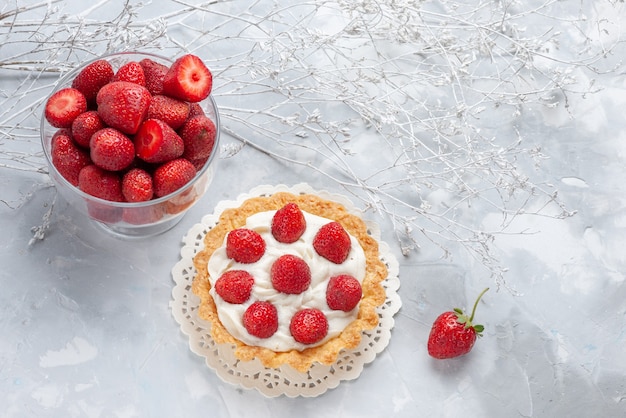 pequeño y delicioso pastel con crema y fresas rojas frescas sobre un escritorio blanco, pastel de crema de baya