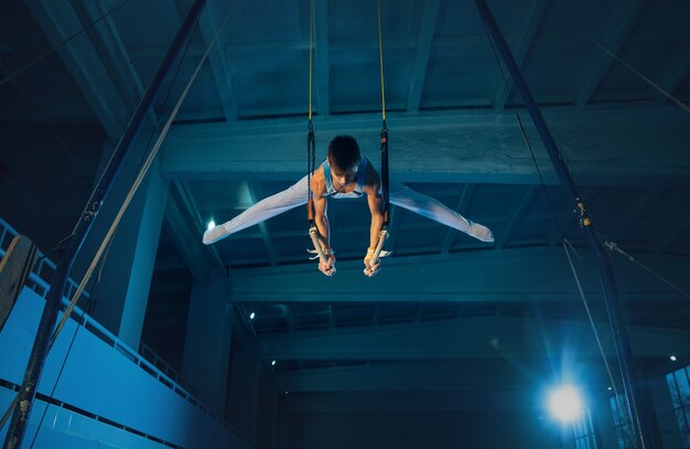 Pequeño gimnasta masculino entrenando en el gimnasio