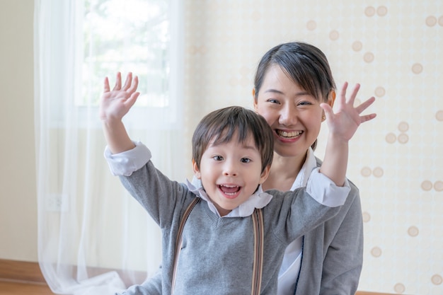 Pequeño niño y joven madre sonriendo y jugando juntos