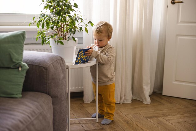 El pequeño niño rubio caucásico usa ropa informal en la sala de luz Concepto de estilo de vida de los niños