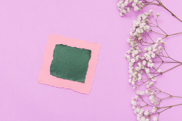 Pequeño papel con ramas de flores en la mesa