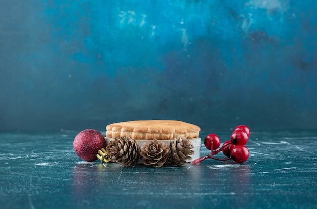 Foto gratuita pequeño pastel de frutas sabroso con bolas de navidad y piñas. foto de alta calidad