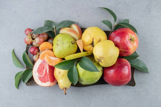 Foto gratuita un pequeño surtido de varias frutas en mármol.