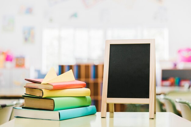 Pequeño tablero de tiza y libros sobre la mesa.