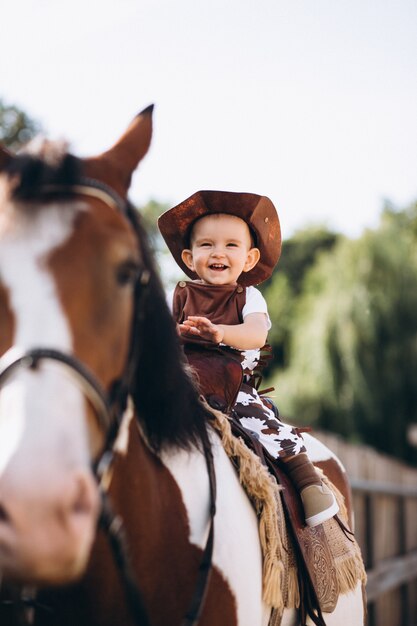 Pequeño vaquero sentado en un caballo