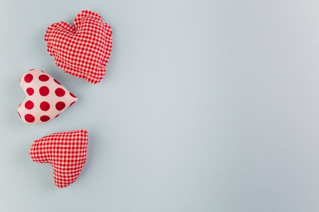 Pequeños corazones brillantes suaves en mesa gris