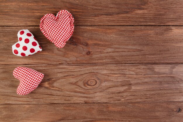 Pequeños corazones brillantes suaves en mesa de madera