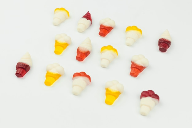 Pequeños dulces en forma de helado sobre fondo blanco